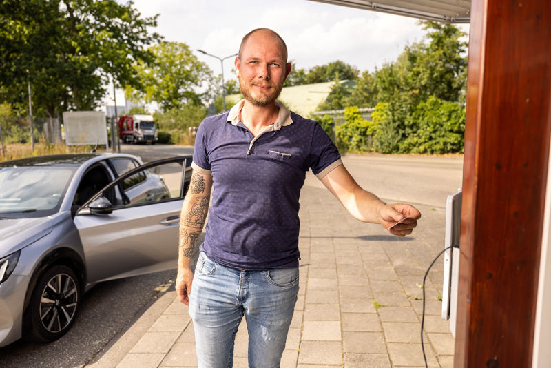 Inwoner Bij Loket Milieustraat En Kijkt In Camera LR Liggend